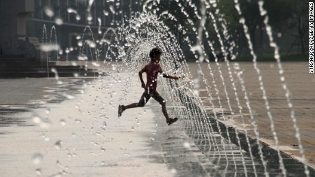 This picture taken on July 26, 2015 shows a child playing in a fountain on a square to cool himself amid a heatwave in Binzhou, eastern China&#39;s Shandong province.   CHINA OUT     AFP PHOTO        (Photo credit should read STR/AFP/Getty Images)
