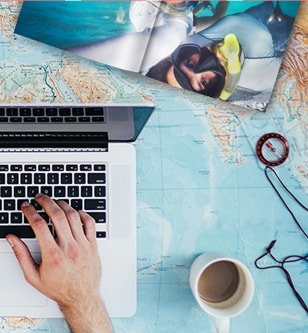 A laptop, travel book, and map